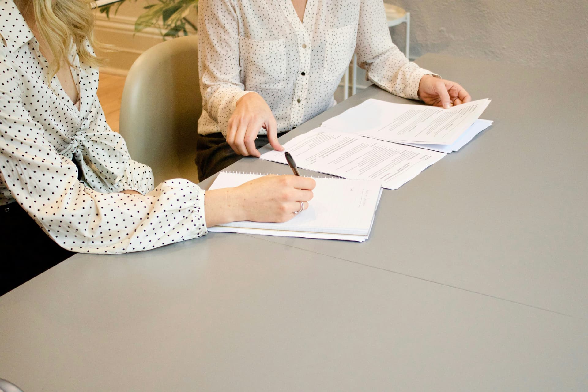 Two professionals reviewing legal documents together at a conference table